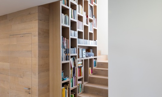 Gli spazi interni ruotano attorno ad una scala libreria, elemento di design e fulcro dell'abitazione 
