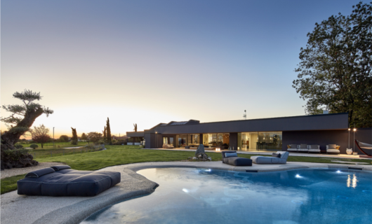 La piscina dalle forme naturali è il coronamento di questa villa in bioedlizia. 